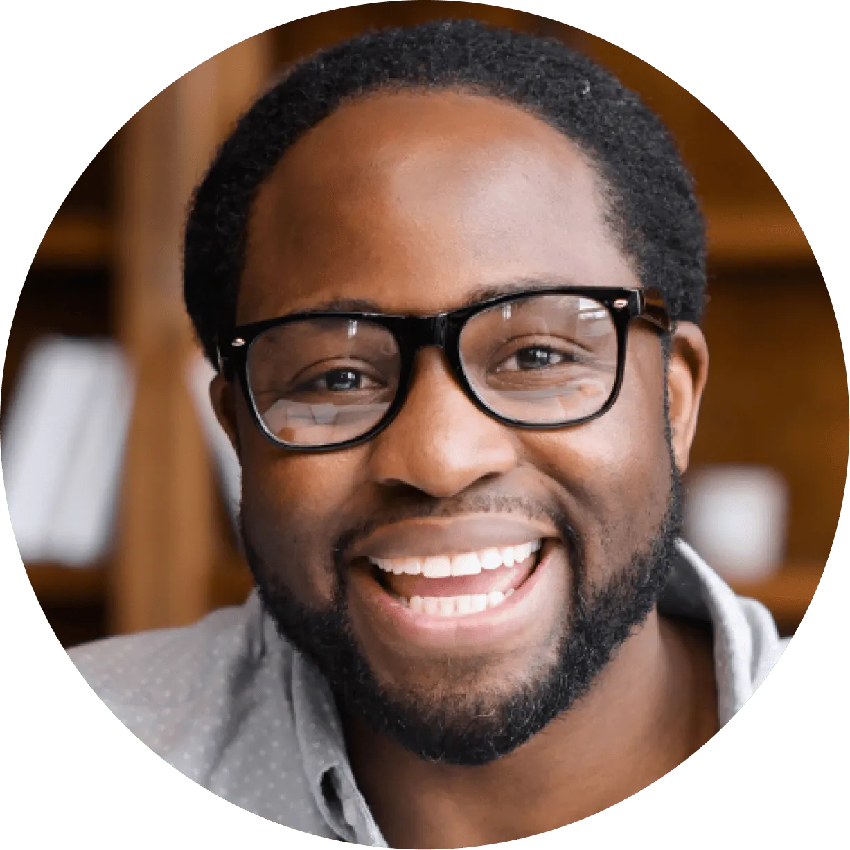 A man with glasses smiling for the camera.